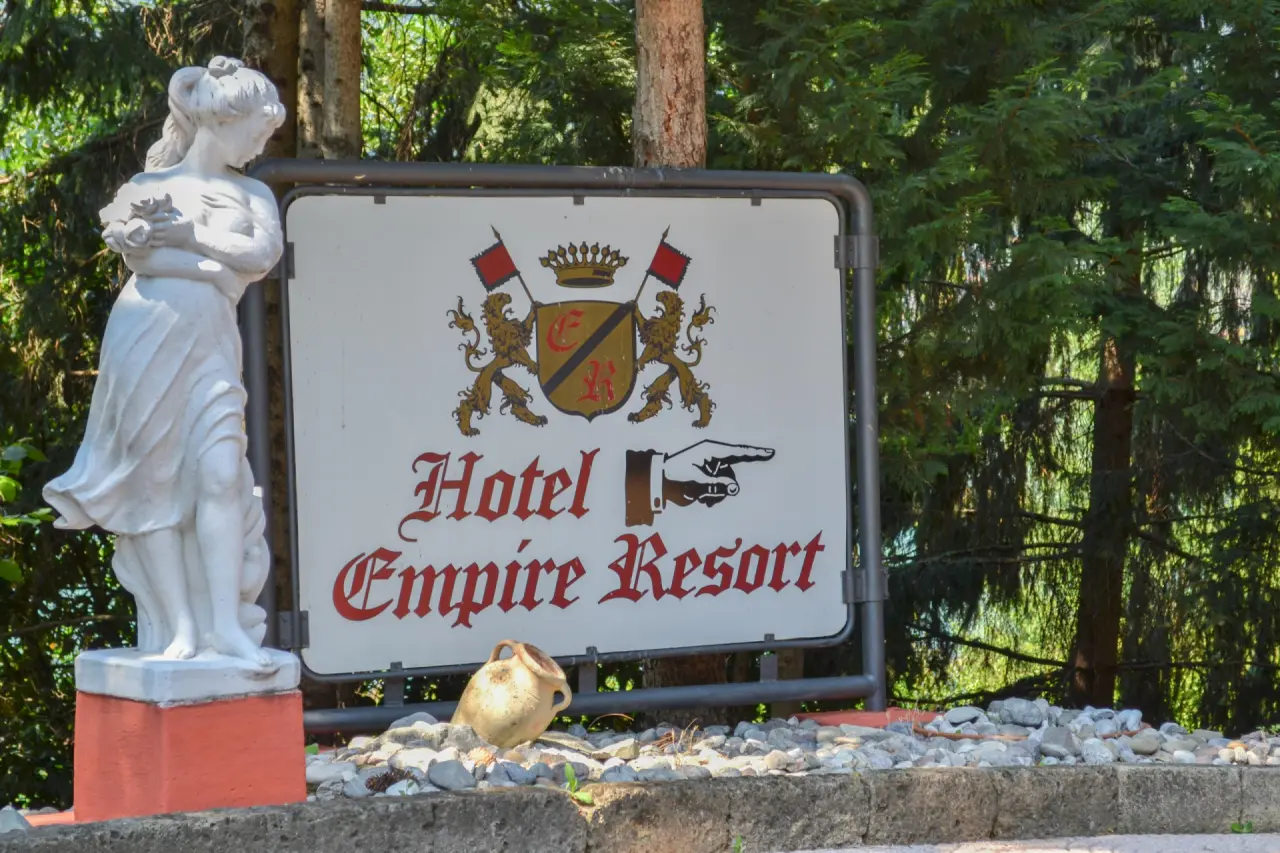 Empire Resort in Litschau – Weißes Hinweisschild mit Logo und Statue im Grünen | Wellnesshotel Waldviertel