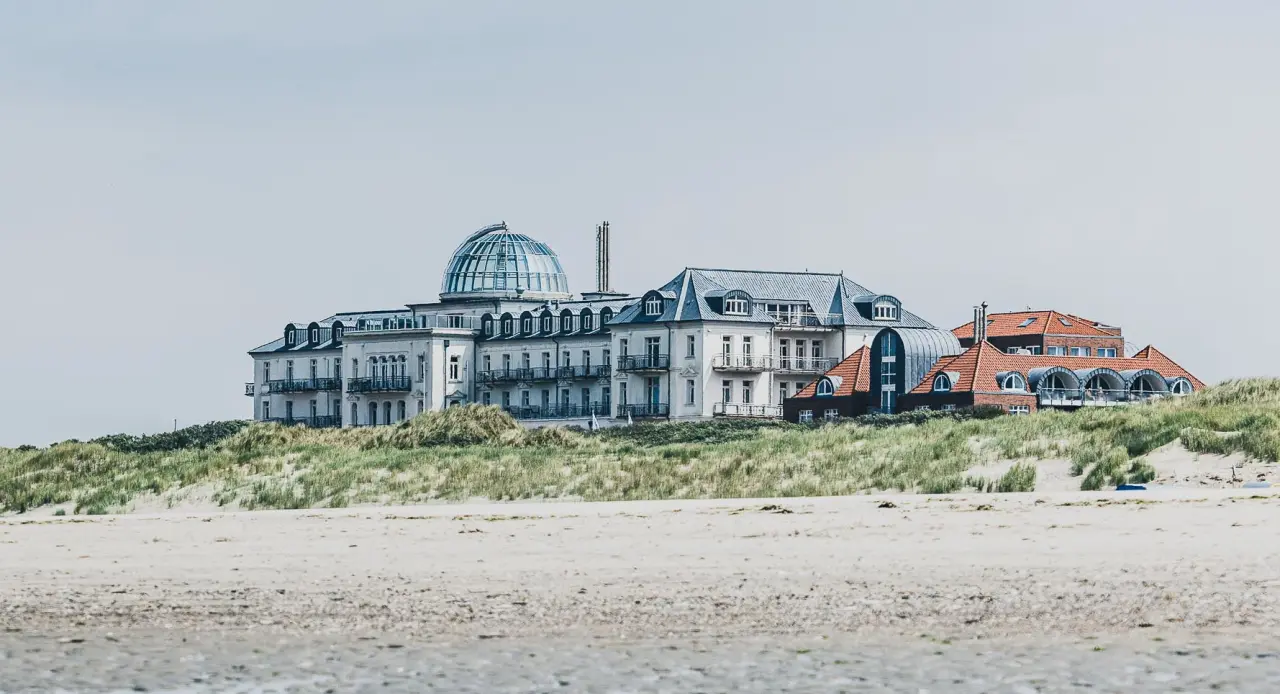 Majestätisches Strandhotel Kurhaus Juist auf den Dünen mit Blick auf den weiten Sandstrand der Nordseeinsel.