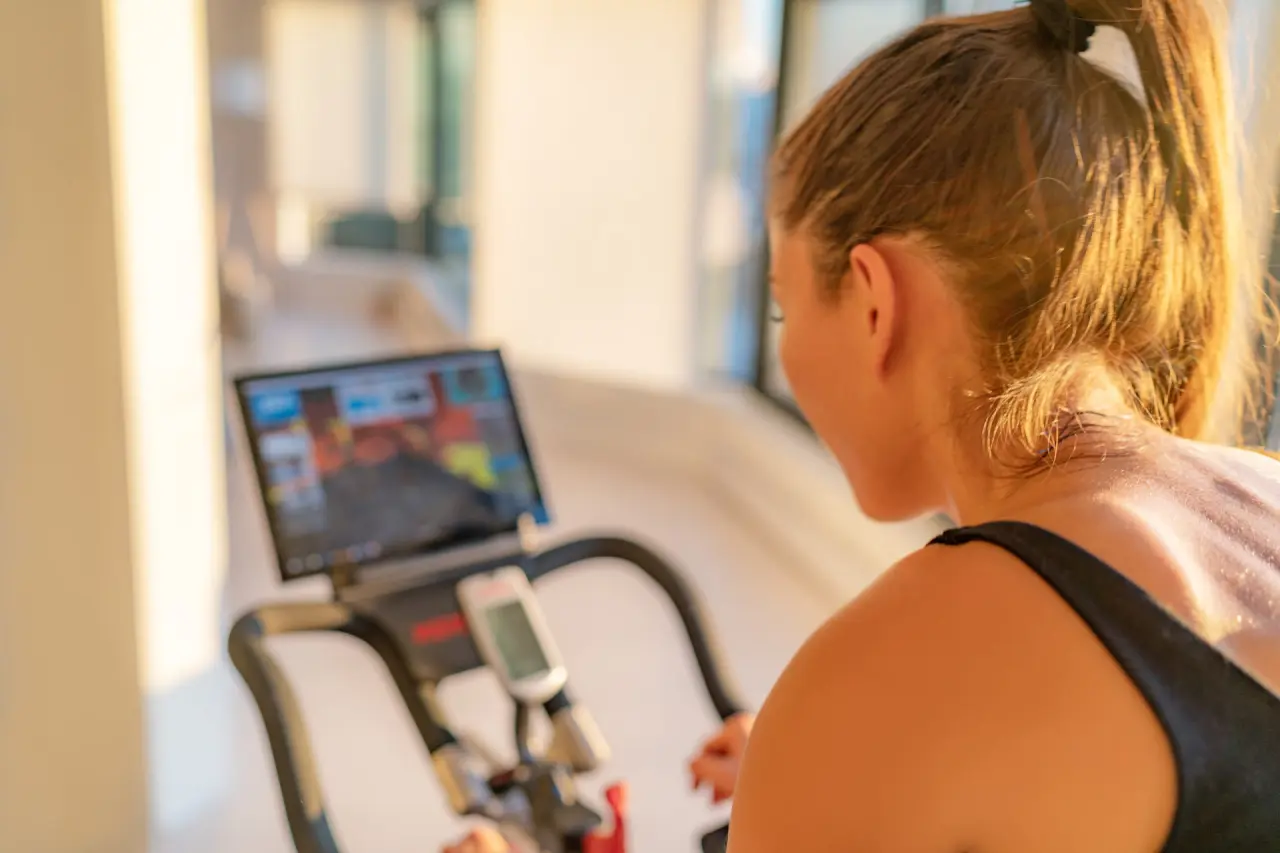 Frau beim Training auf einem Ergometer im Fitnessbereich des Strandhotel Kurhaus Juist.