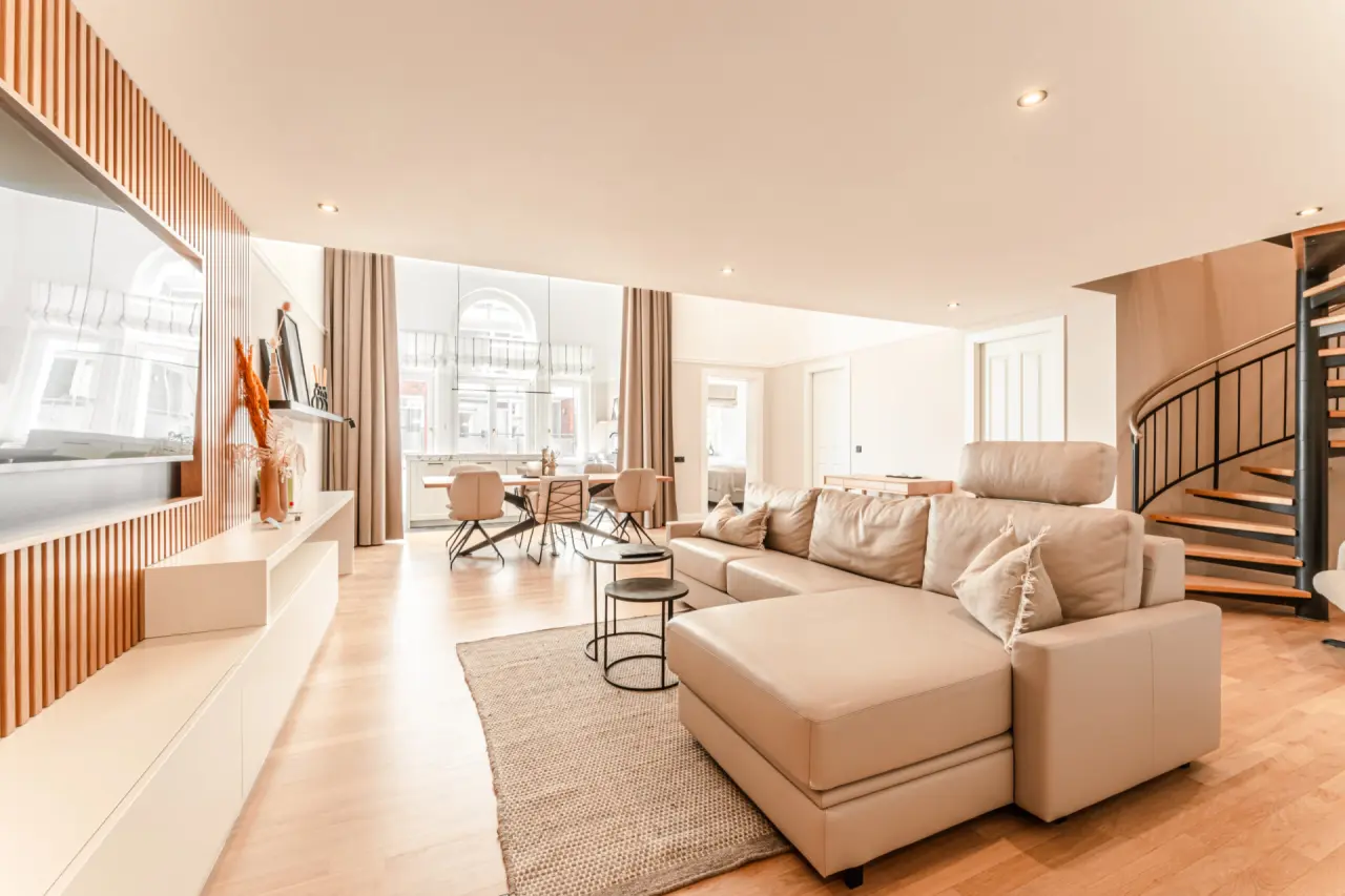 Geräumige Suite mit modernem Wohnbereich, Essbereich und Wendeltreppe im Strandhotel Kurhaus Juist.