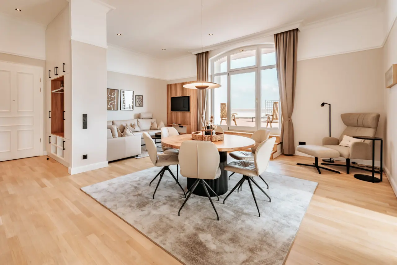 Helle, moderne Suite mit Essbereich, Sofa und Balkon im Strandhotel Kurhaus Juist.