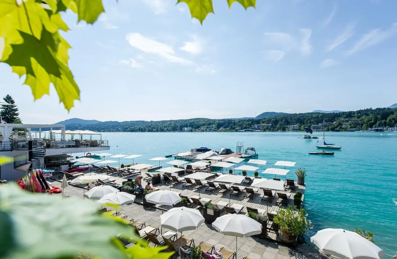 Sonnige Seeterrasse mit Liegestühlen und Schirmen am Wörthersee im Hotel Post Velden.