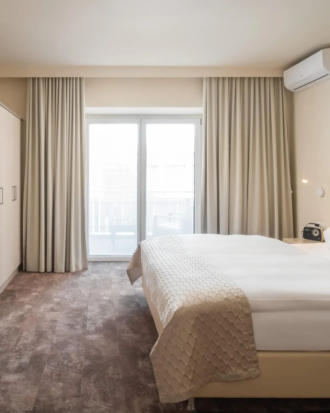 Helles Doppelzimmer mit Balkon und modernem Interieur im Hotel Post Velden.