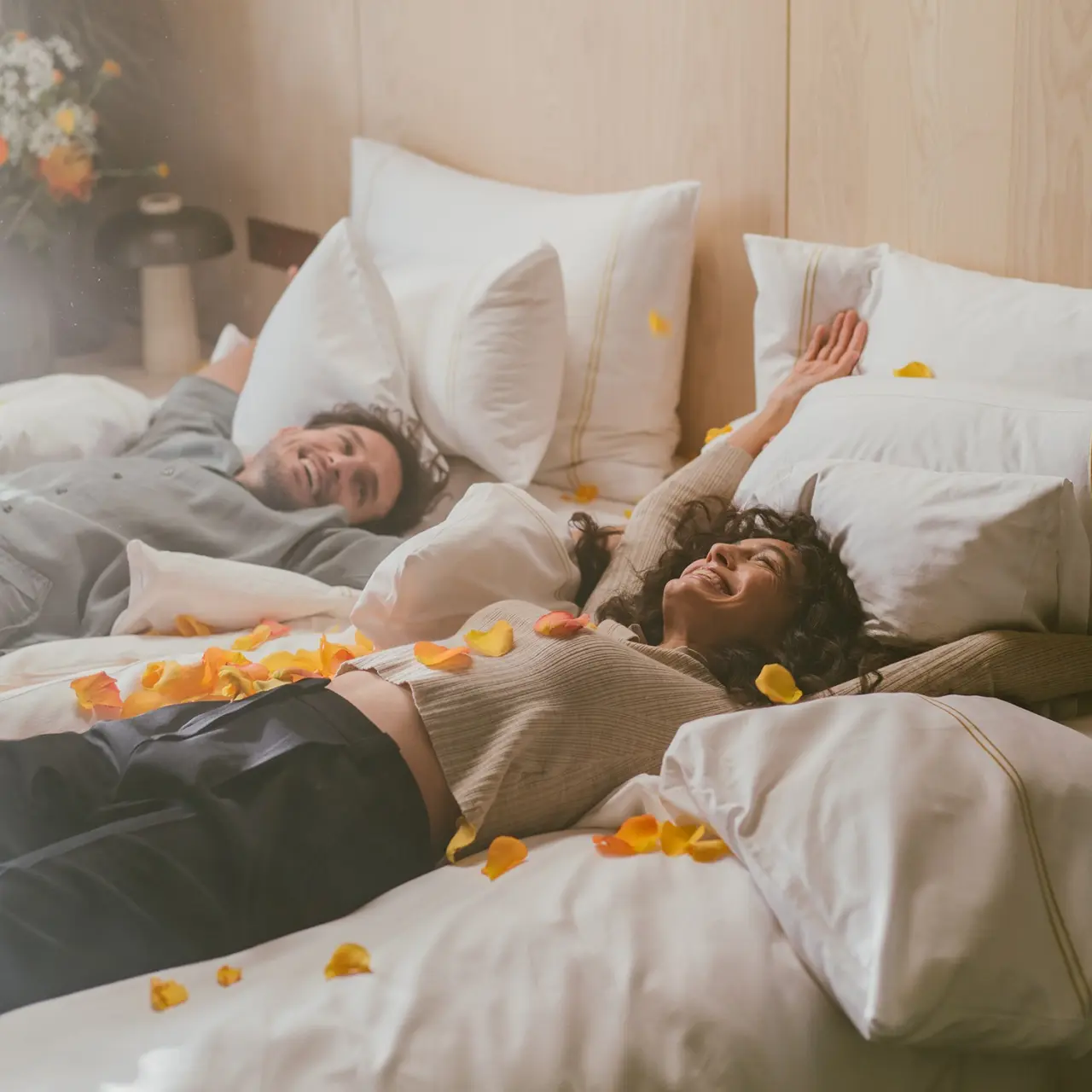 Glückliches Paar entspannt im luxuriösen Hotelzimmer mit Rosenblättern im Hotel Reiters Supreme.