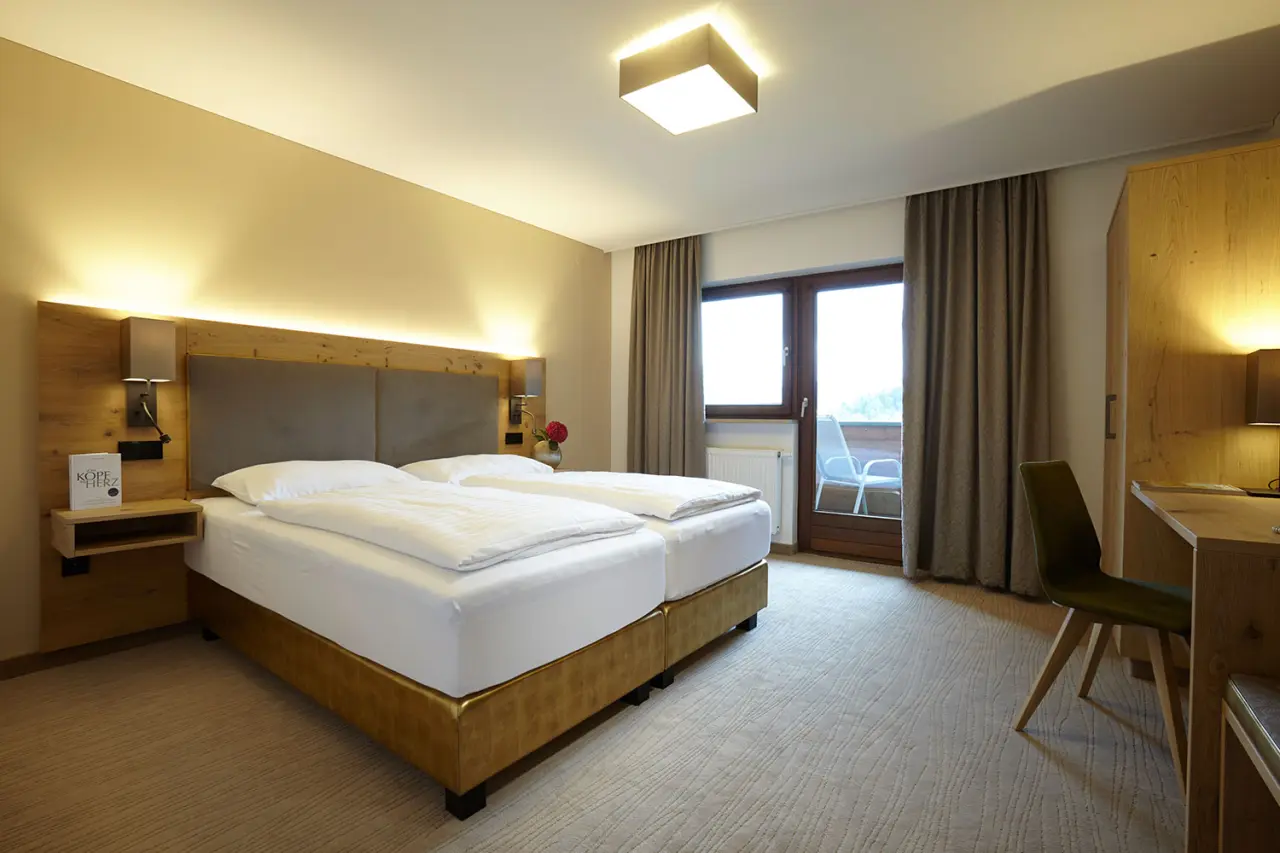 Gemütliches Doppelzimmer mit Balkon, Holzelementen und bequemen Betten im Hotel DER HECHL.