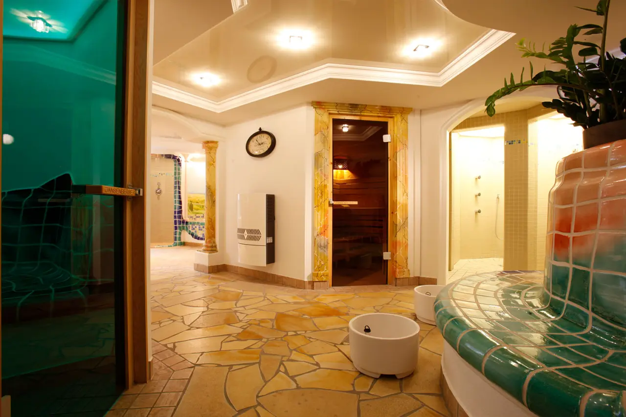 Umfassender Wellnessbereich im Hotel DER HECHL mit Sauna, Dampfbad, Erlebnisduschen und Mosaik-Entspannungsbank.