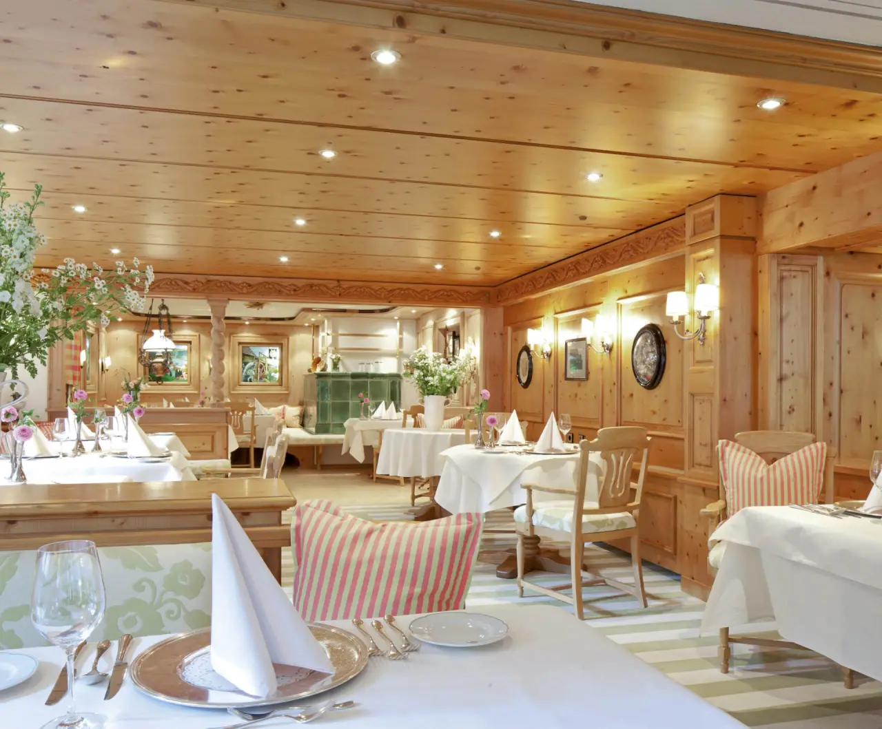 Gemütliches Restaurant im alpinen Stil mit Holzeinrichtung und festlich gedeckten Tischen im Hotel Kesslermühle.