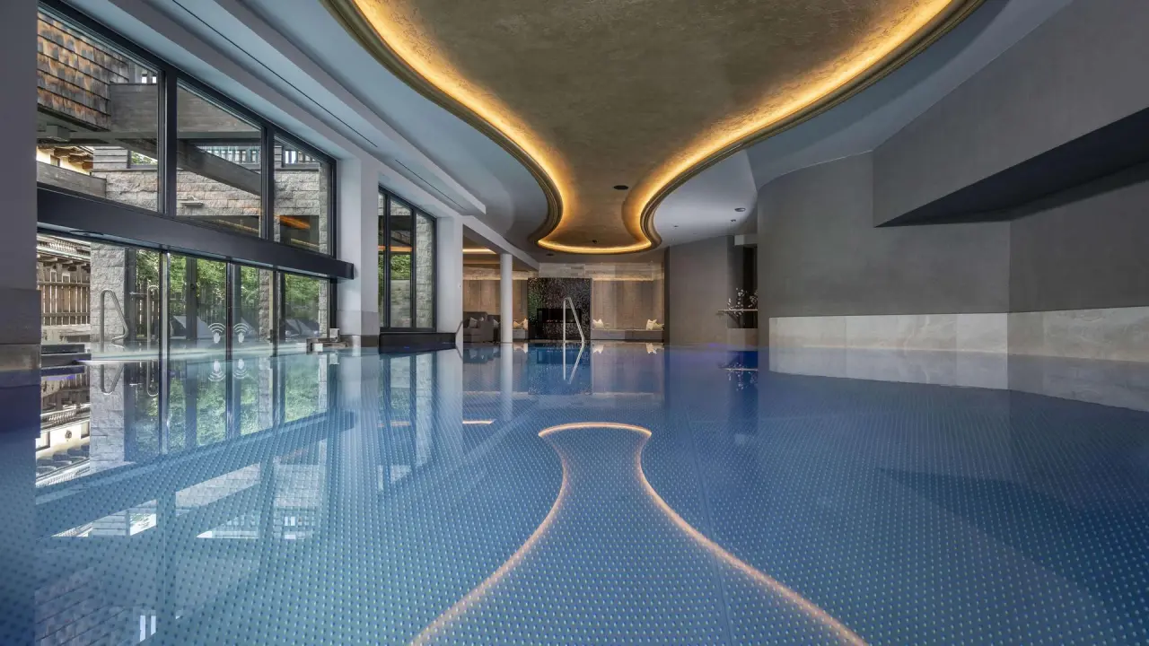 Luxuriöser Innenpool mit stilvoller Deckenbeleuchtung und großen Fenstern im Hotel Kendler.