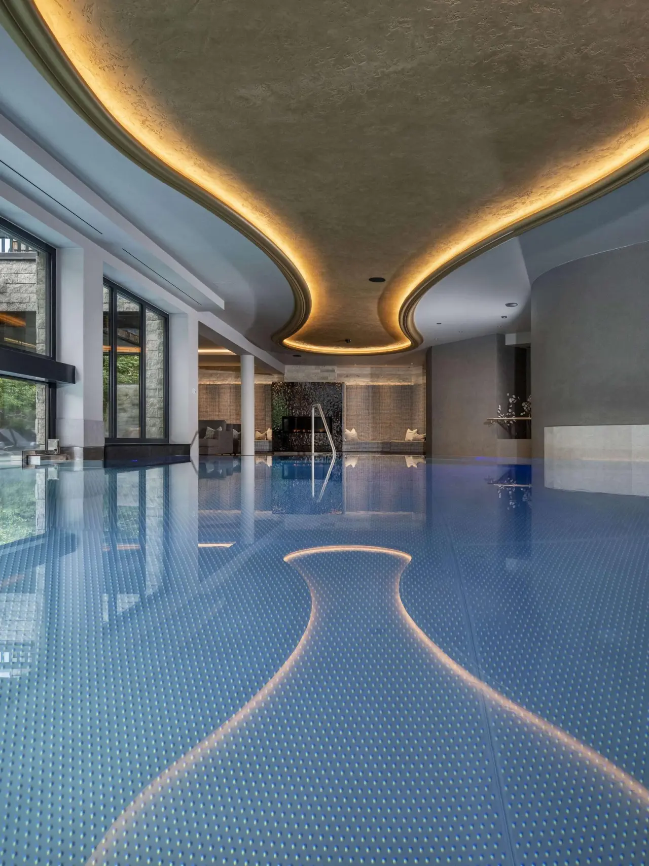 Modernes Hallenbad mit indirekter Beleuchtung und grossen Fenstern im Hotel Kendler. Einladende Poollandschaft.
