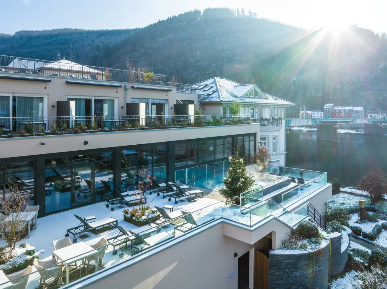 Winterliche Aussenansicht des Moselschlösschen Spa & Resort mit beheiztem Aussenpool, Liegen und Moselblick.