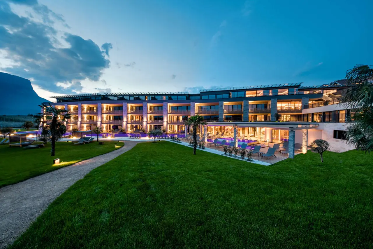 Weinegg Wellviva Resort in Girlan – Beleuchtete Hotel-Außenansicht mit Pool und Garten | Wellnesshotel Südtirol