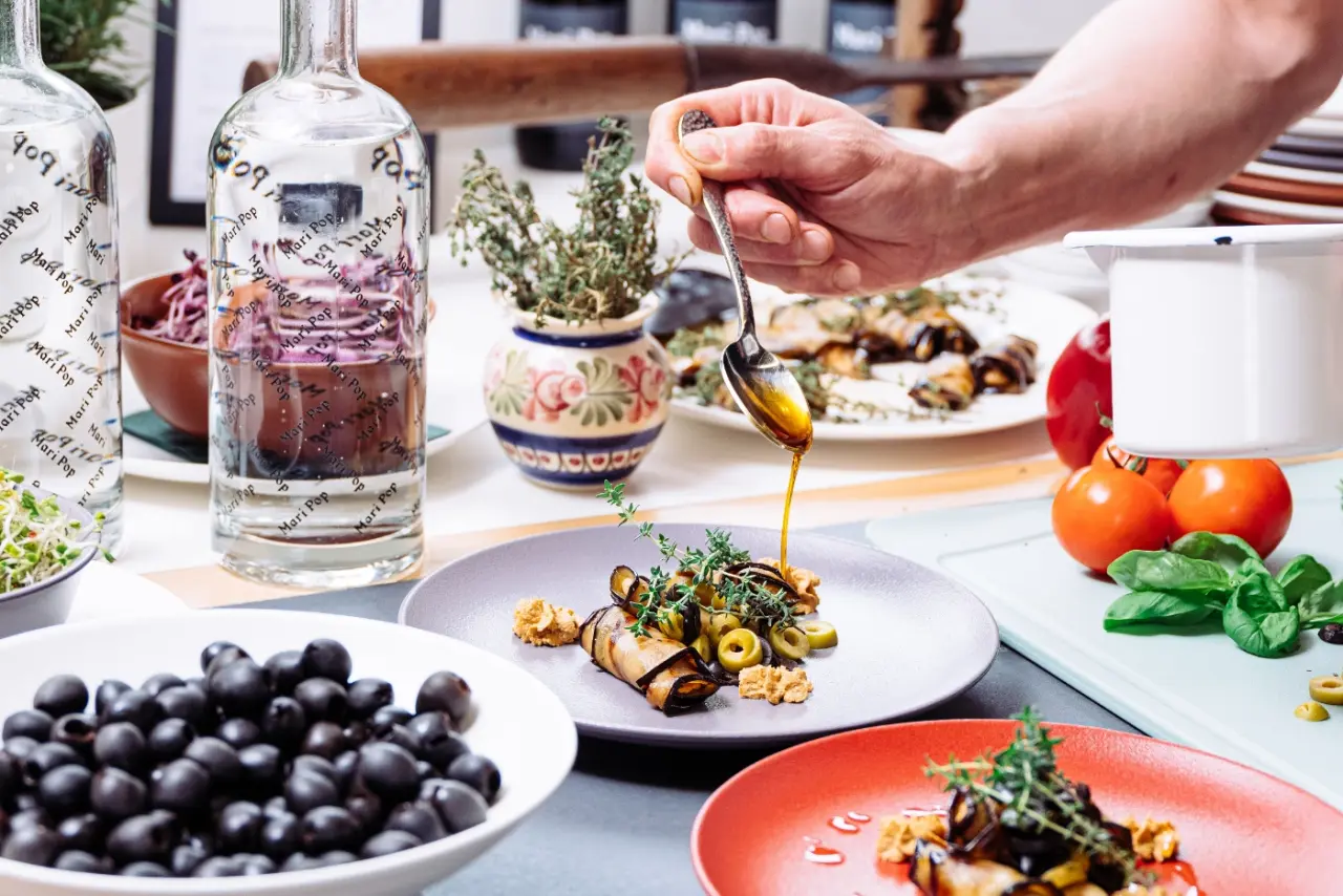 Zubereitung von mediterranen Vorspeisen mit Oliven und Auberginen im Restaurant des Mari Pop Hotel Zillertal.