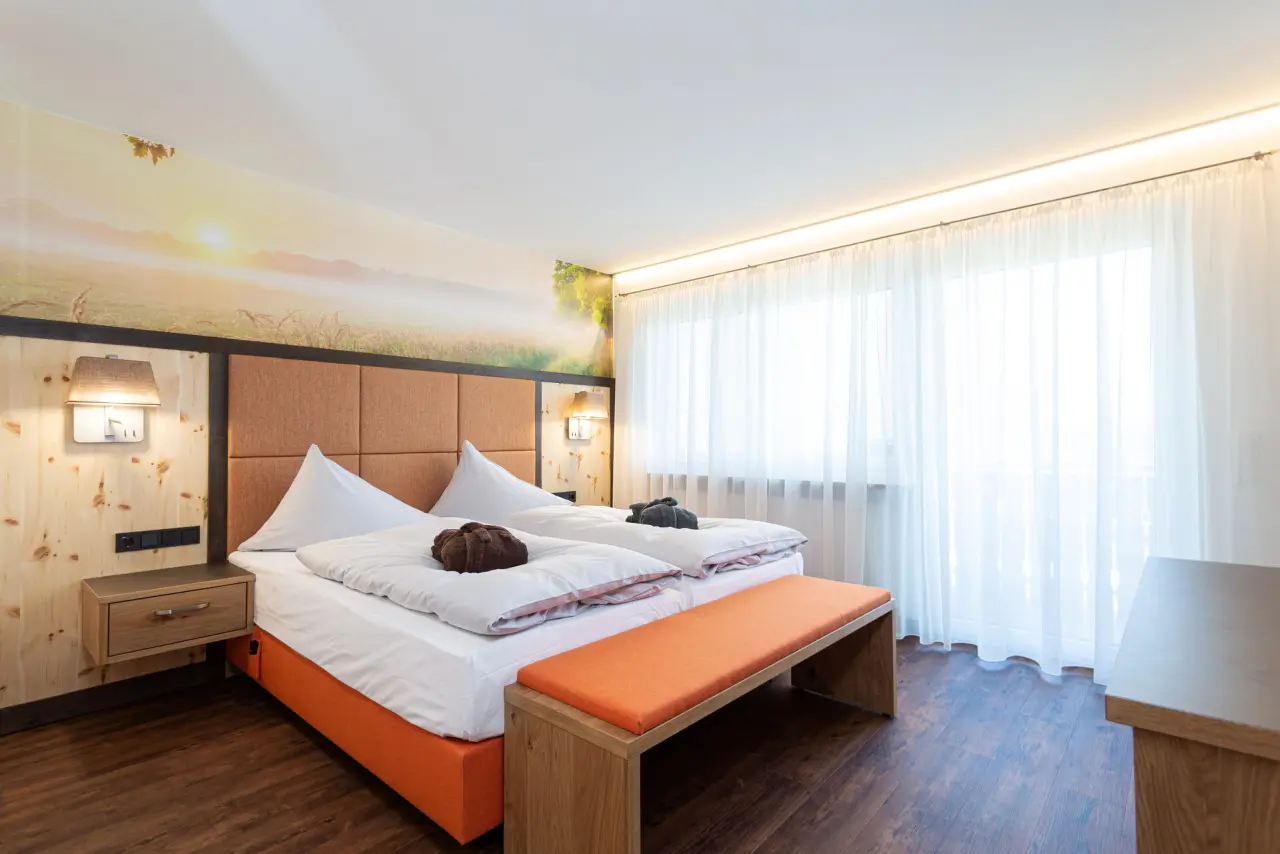Gemütliches Doppelzimmer mit Holzelementen, bequemen Betten und Landschaftstapete im Thermenhotel Gass, Bad Füssing.