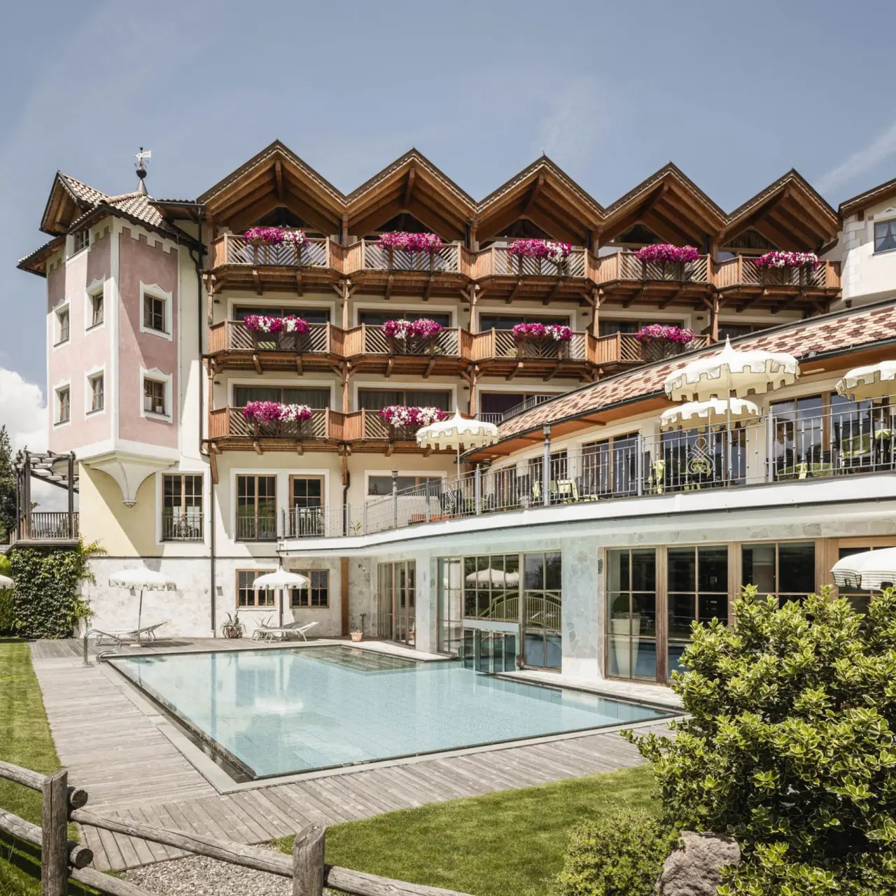 Hotel Chalet Tianes in Kastelruth – Außenansicht mit Pool und Blumenbalkonen | Wellnesshotel Südtirol