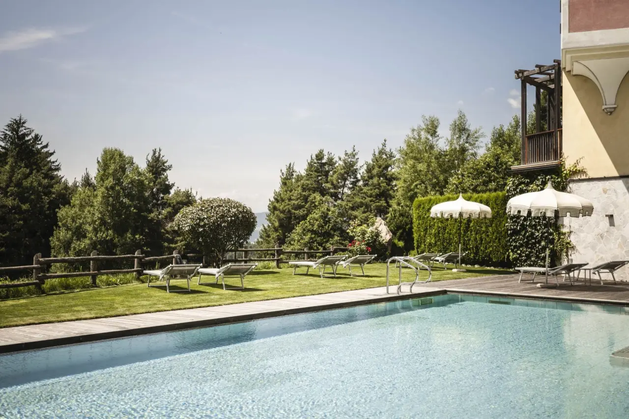 Hotel Chalet Tianes in Kastelruth – Außenpool mit Liegewiese und Sonnenschirmen | Wellnesshotel Südtirol