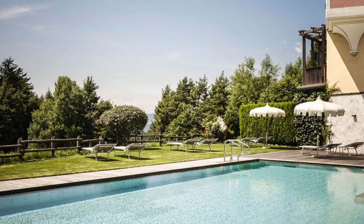 Hotel Chalet Tianes in Kastelruth – Außenpool mit Liegewiese und Sonnenschirmen | Wellnesshotel Südtirol