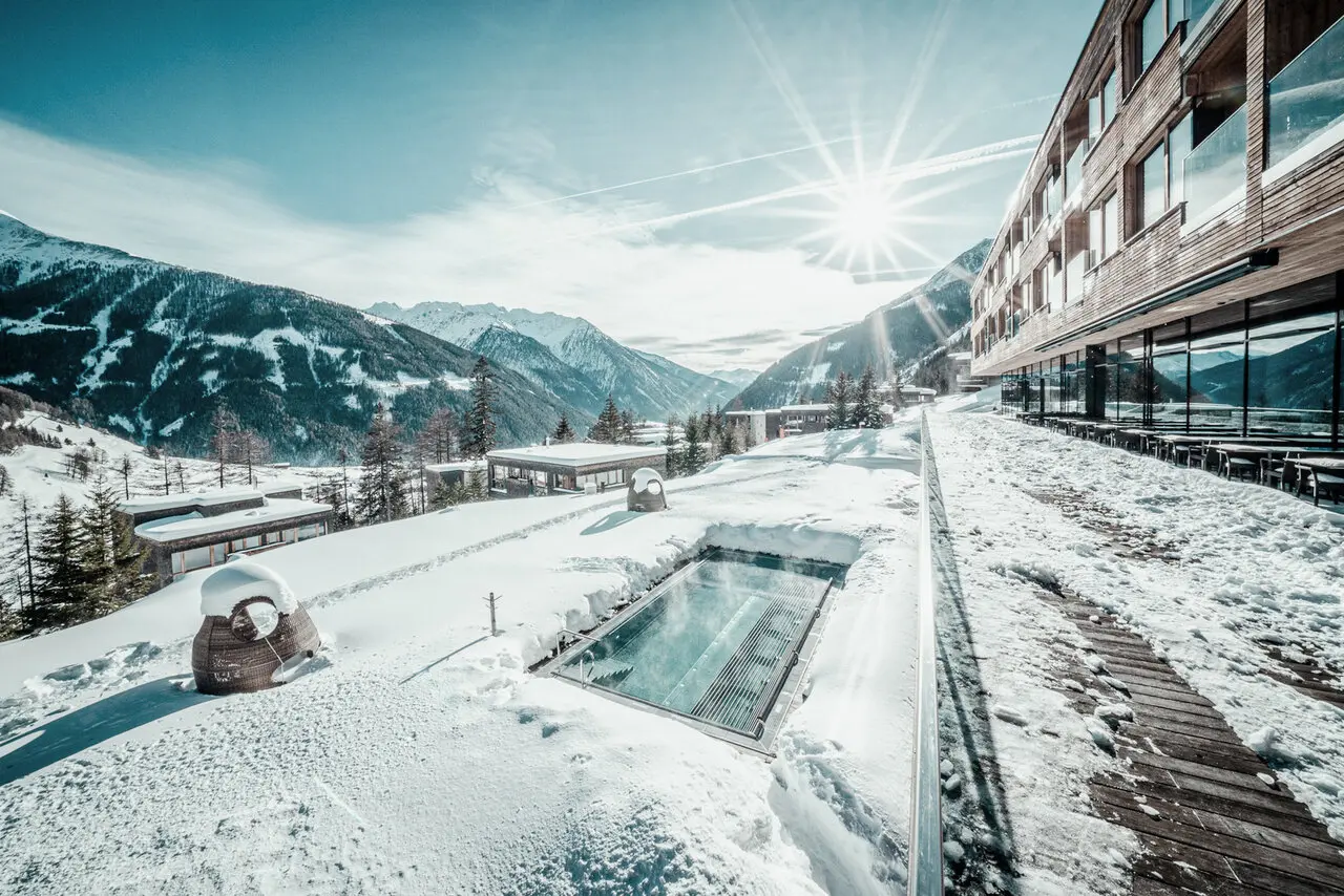 Beheizter Aussenpool im Schnee mit Bergpanorama am Gradonna****s Mountain Resort Châlets & Hotel.