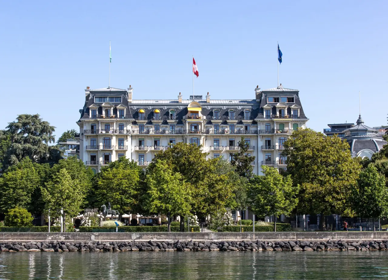 Grandioses Hotel Beau Rivage Palace am Genfersee mit klassischer Architektur und grüner Uferpromenade.