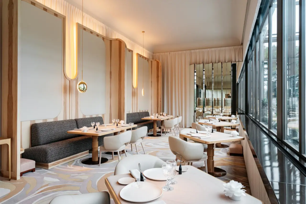 Elegantes Restaurant im Hotel Beau Rivage Palace mit modernen Möbeln, großen Fenstern und stilvoller Beleuchtung.
