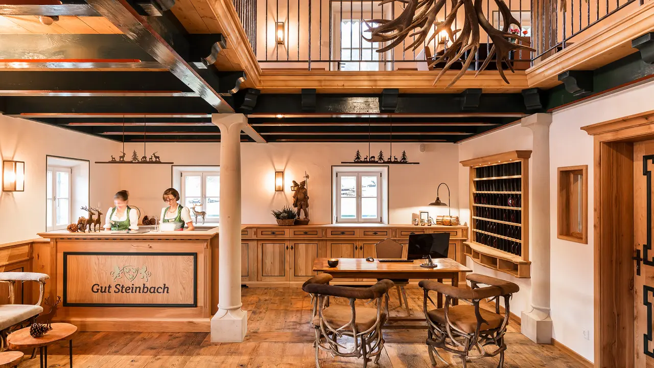 Traditionelle Rezeption mit Holzinterieur und freundlichem Personal im Gut Steinbach Hotel Chalets SPA