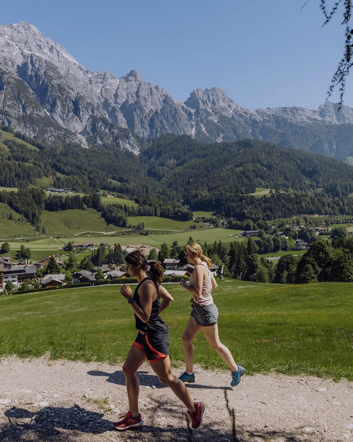 Naturresort Puradies in Leogang – Zwei Frauen joggen vor beeindruckendem Bergpanorama | Wellnesshotel Salzburger Land