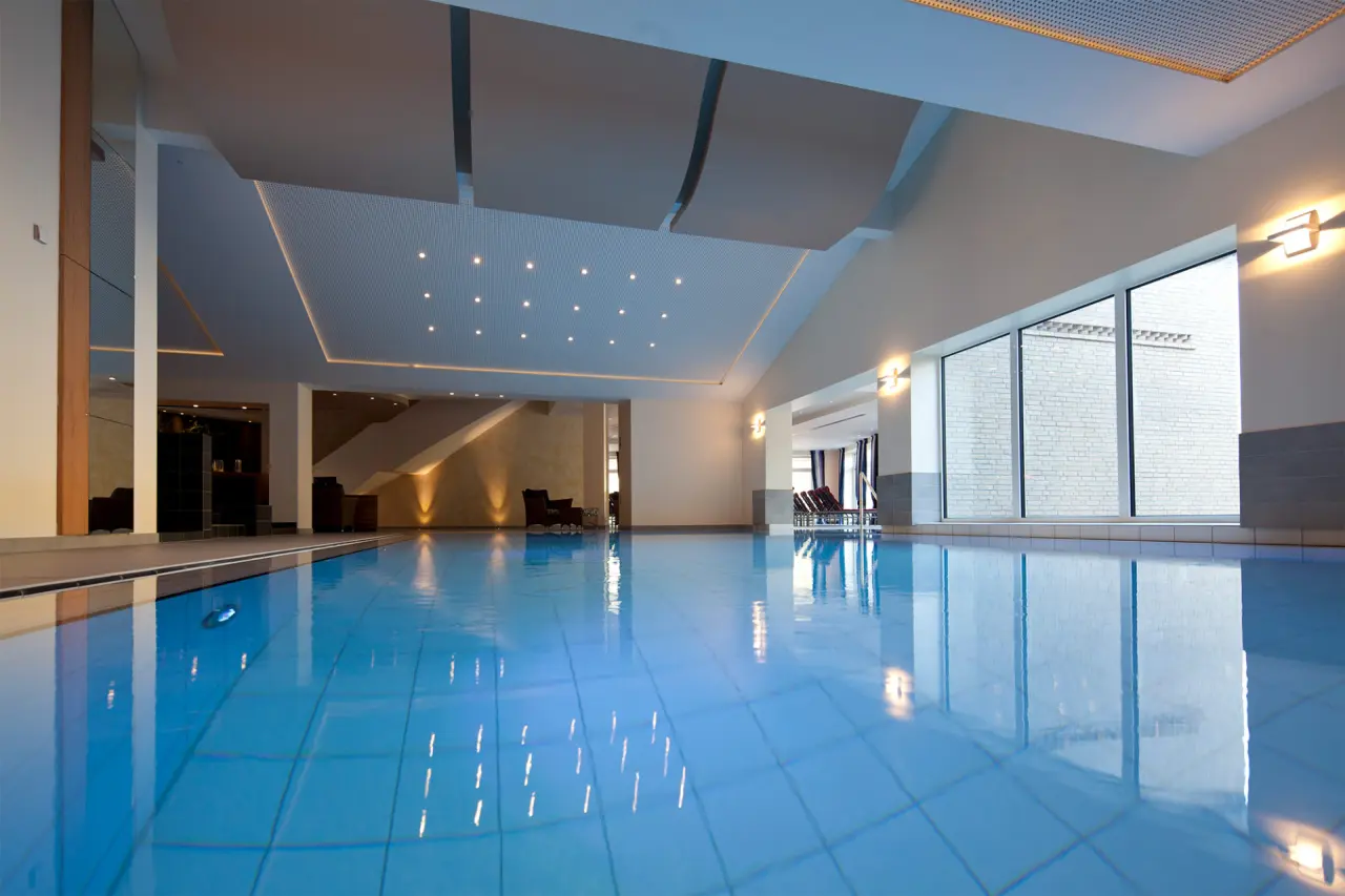 Modernes Hallenbad mit stilvoller Beleuchtung und Liegebereich im Hotel Waldschlösschen für entspannte Stunden.