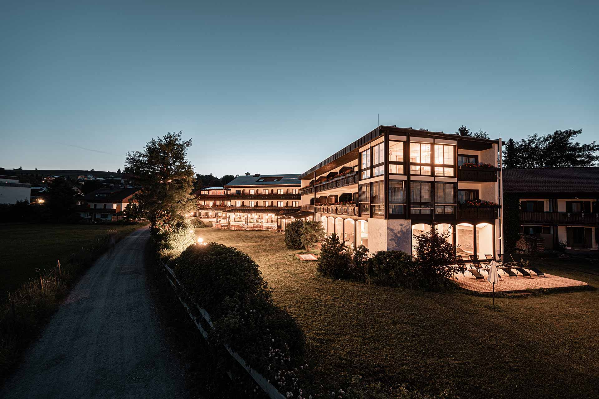 Mittelburg Wellnesshotel in Oy-Mittelberg – Hotelaußenansicht bei Dämmerung mit beleuchteten Fenstern | Wellnesshotel Allgäu