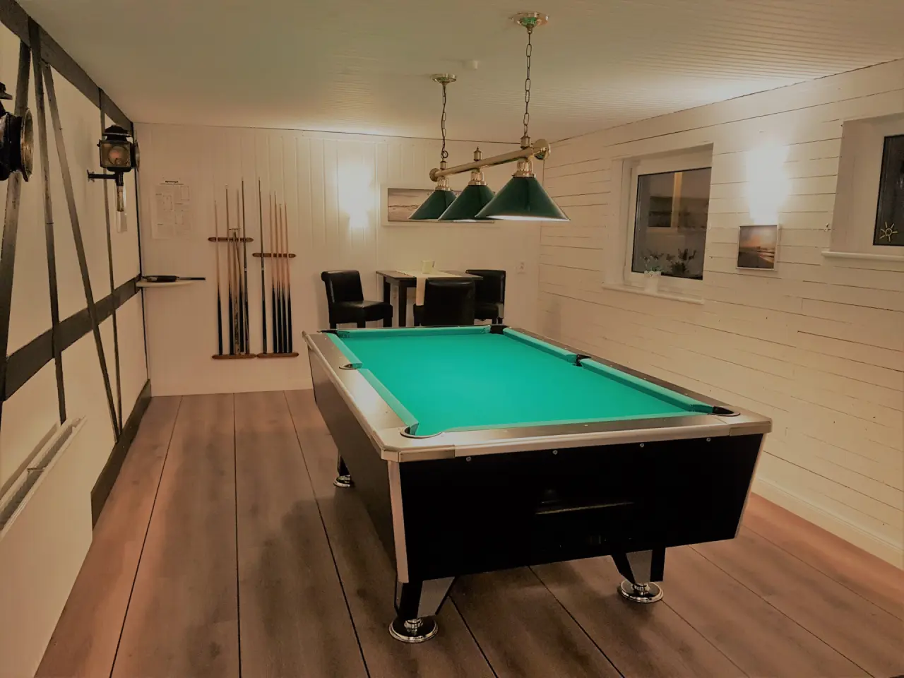 Billardzimmer im HofHotel Krähenberg mit grünem Billardtisch, Holzfußboden und rustikalen Holzbalken.