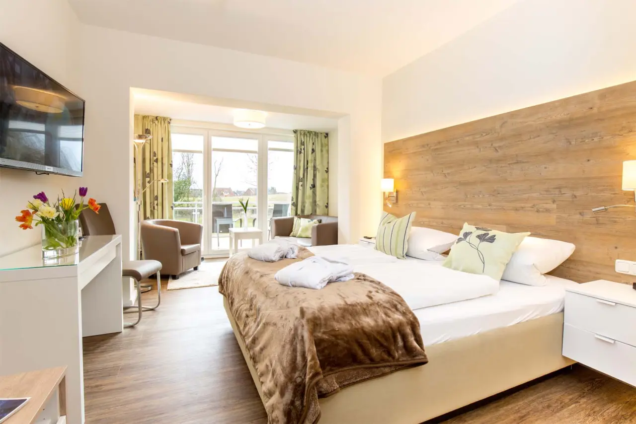 Helles, modernes Doppelzimmer mit Balkon und Bademänteln im HofHotel Krähenberg