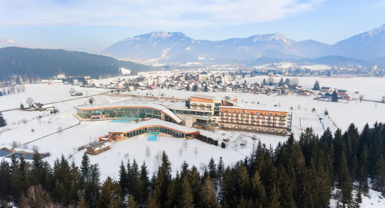 Panoramablick auf den Aldiana Club Salzkammergut im Winter mit modernem Spa-Bereich, Aussenpools und verschneiter Berglandschaft.