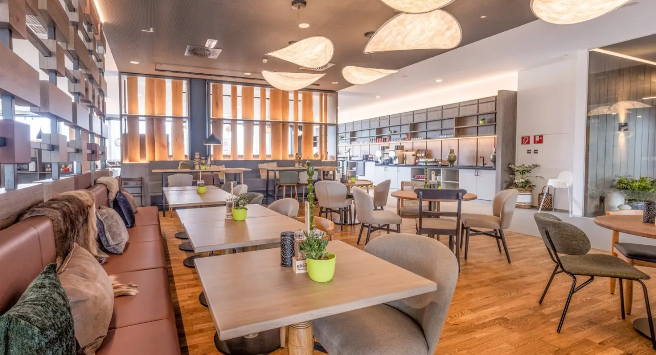 Modernes Restaurant mit gemütlichen Sitzbereichen und Buffet im Aldiana Club Salzkammergut.
