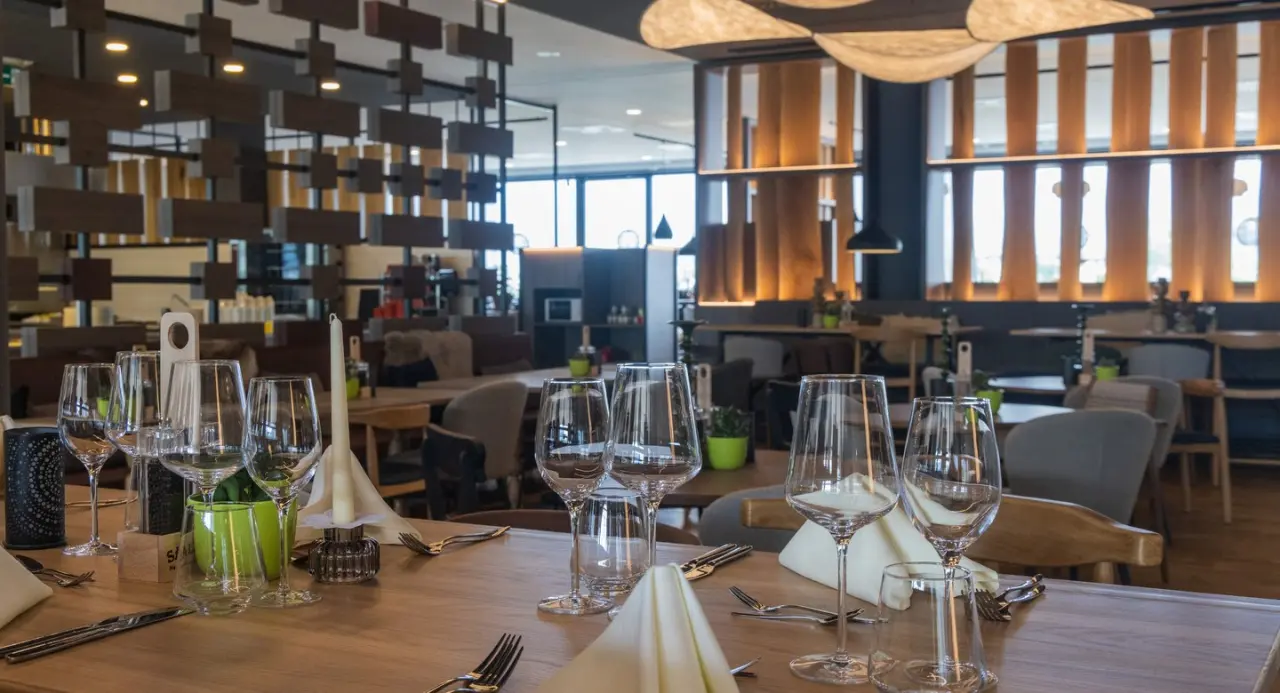 Modern eingerichtetes Restaurant im Aldiana Club Salzkammergut mit elegant gedeckten Tischen und stilvoller Beleuchtung.