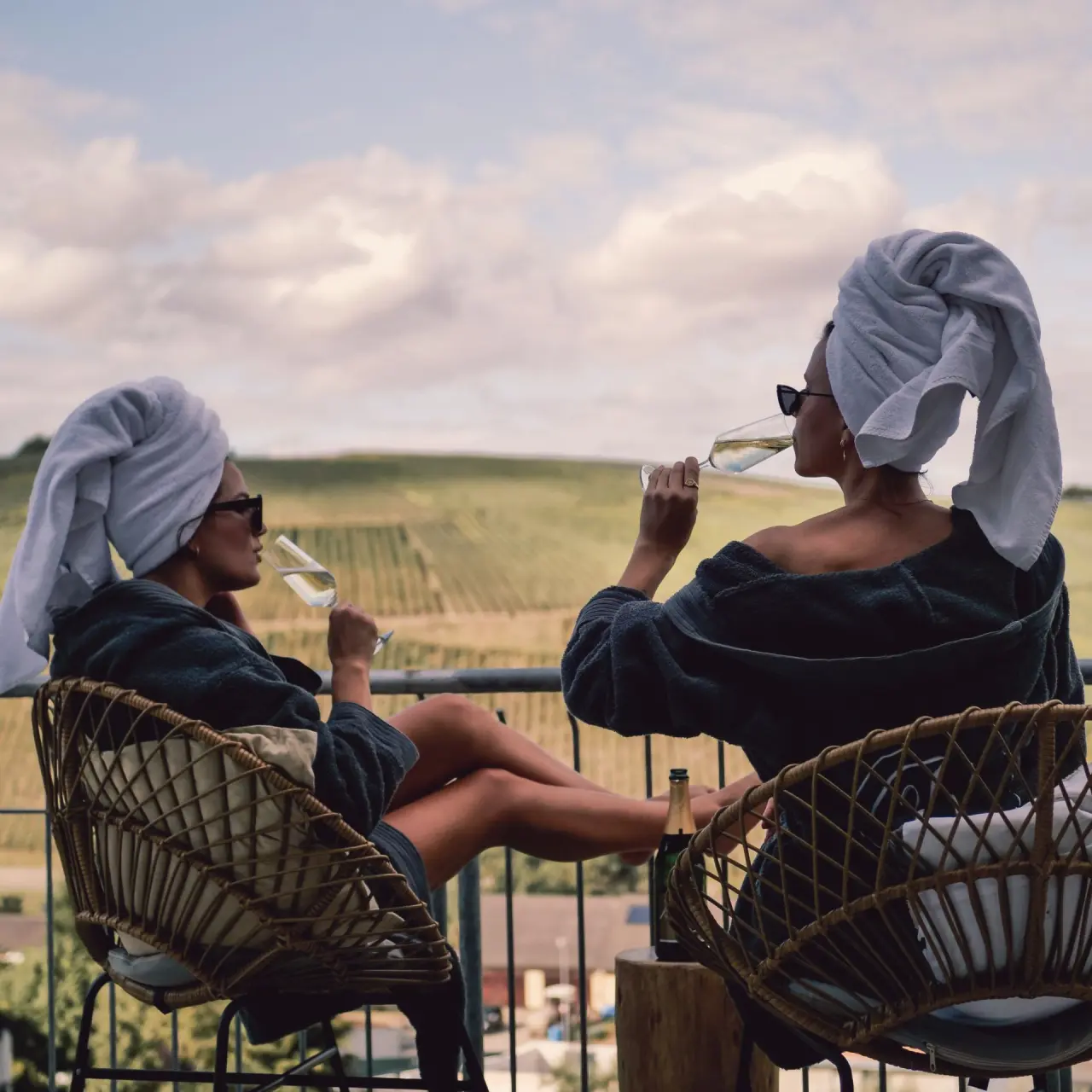 Entspannung auf dem Balkon: Zwei Frauen in Bademänteln mit Sekt und Weinbergblick im Mana Lisa Boutiquehotel.