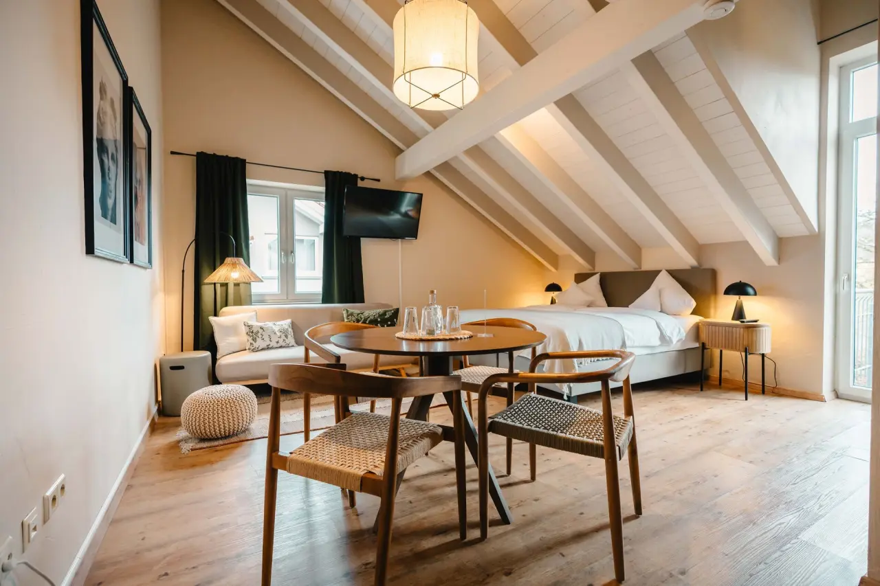 Gemütliches Doppelzimmer mit Holzbalken, Sitzbereich und Esstisch im Mana Lisa Boutiquehotel.