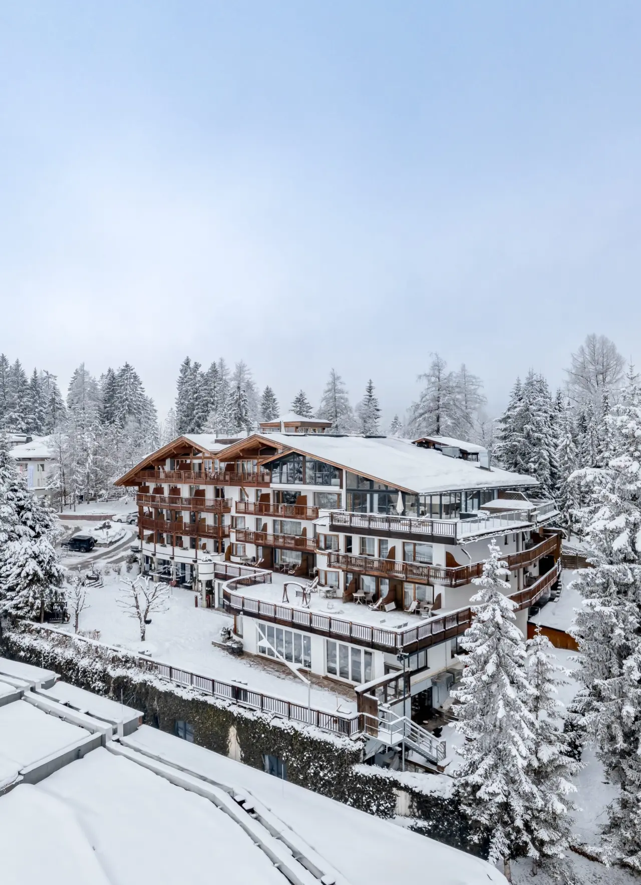 Majestätische Winteransicht des Natur & Spa Hotel Lärchenhof, eingebettet in eine idyllische, tief verschneite Alpenlandschaft.