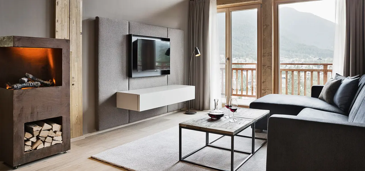 Gemütliches Hotelzimmer mit Kamin, Sofa, TV und Balkon mit Bergblick im Natur & Spa Hotel Lärchenhof.