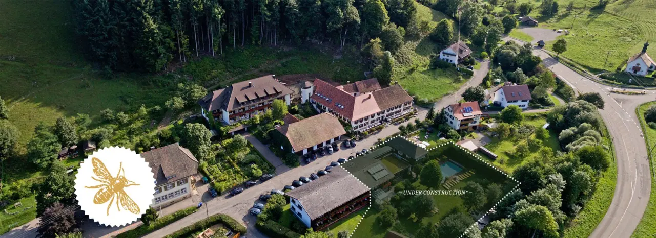 Luftaufnahme des Romantik Hotel Spielweg in grüner Schwarzwaldlandschaft mit Hotelgebäuden und einem markierten Bereich 'Under Construction'.