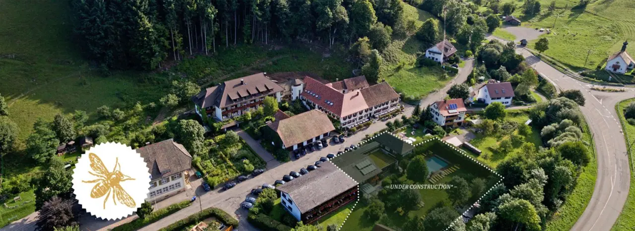 Luftaufnahme des Romantik Hotel Spielweg im Schwarzwald mit Hotelanlage, umliegenden Wäldern und Wiesen.