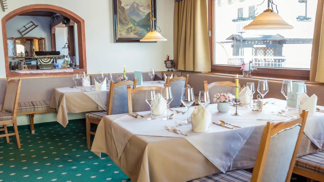 Gemütlich gedeckter Restaurantbereich im Appart- und Wellnesshotel Charlotte Seefeld mit Blick nach draußen.