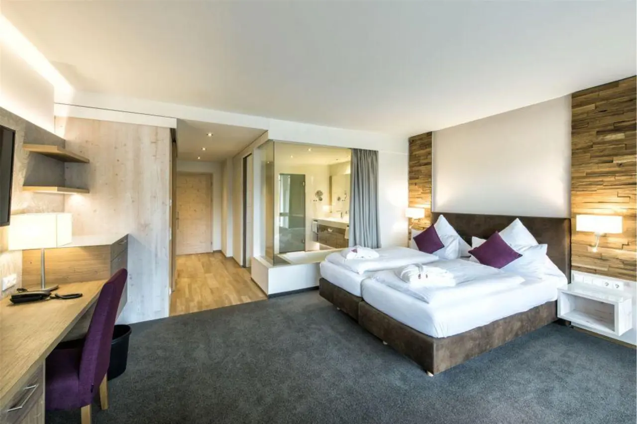 Modernes Doppelzimmer mit Holzelementen und offenem Bad im Landhaus Sponsel-Regus.