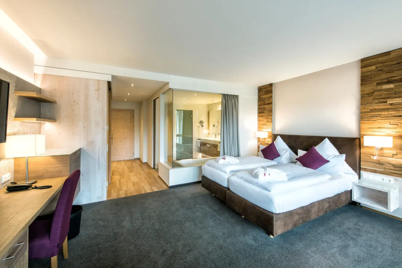 Modernes Doppelzimmer im Landhaus Sponsel-Regus mit Holzelementen, Schreibtisch und offenem Badbereich.