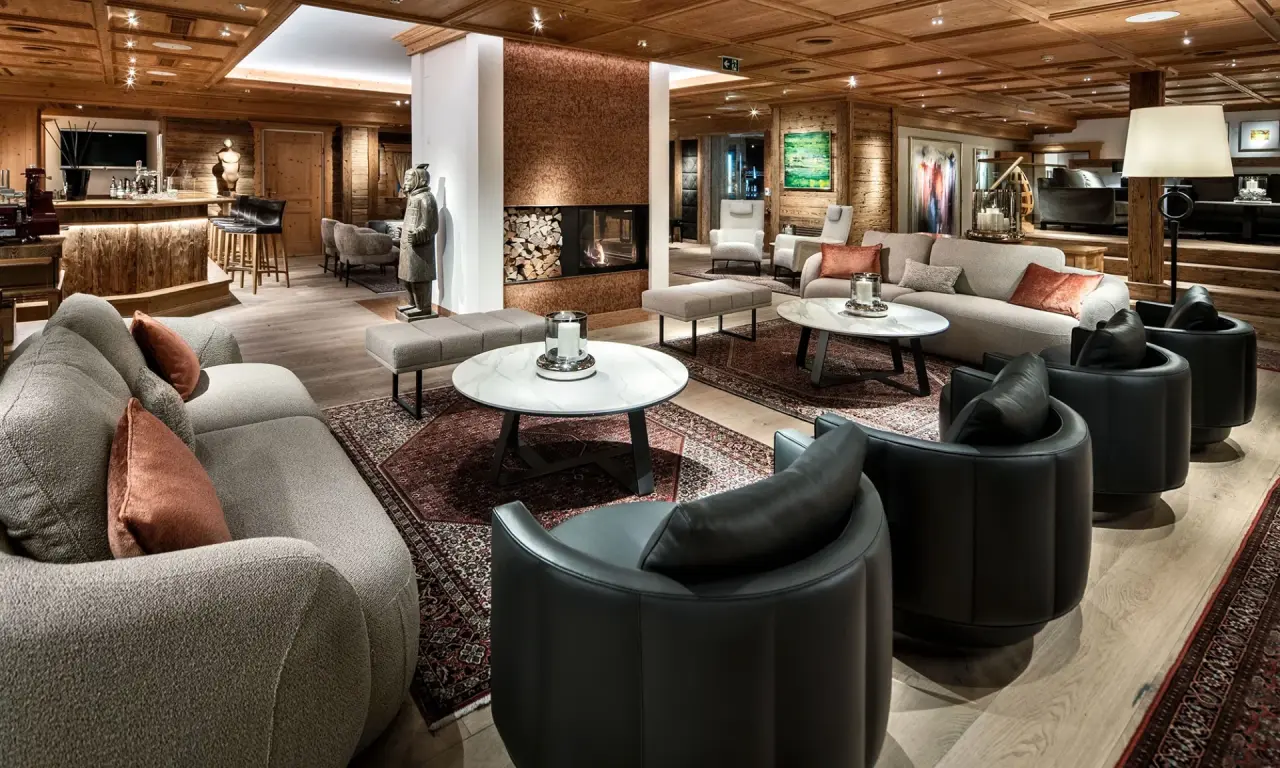 Luxuriöse Hotellobby mit Kamin, gemütlichen Sitzbereichen und Bar im Burg Vital Resort.