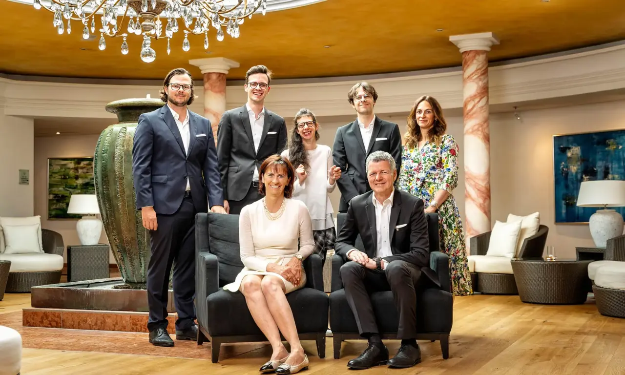 Familie und Management des Burg Vital Resort posieren für ein Gruppenfoto in der eleganten Hotellobby.