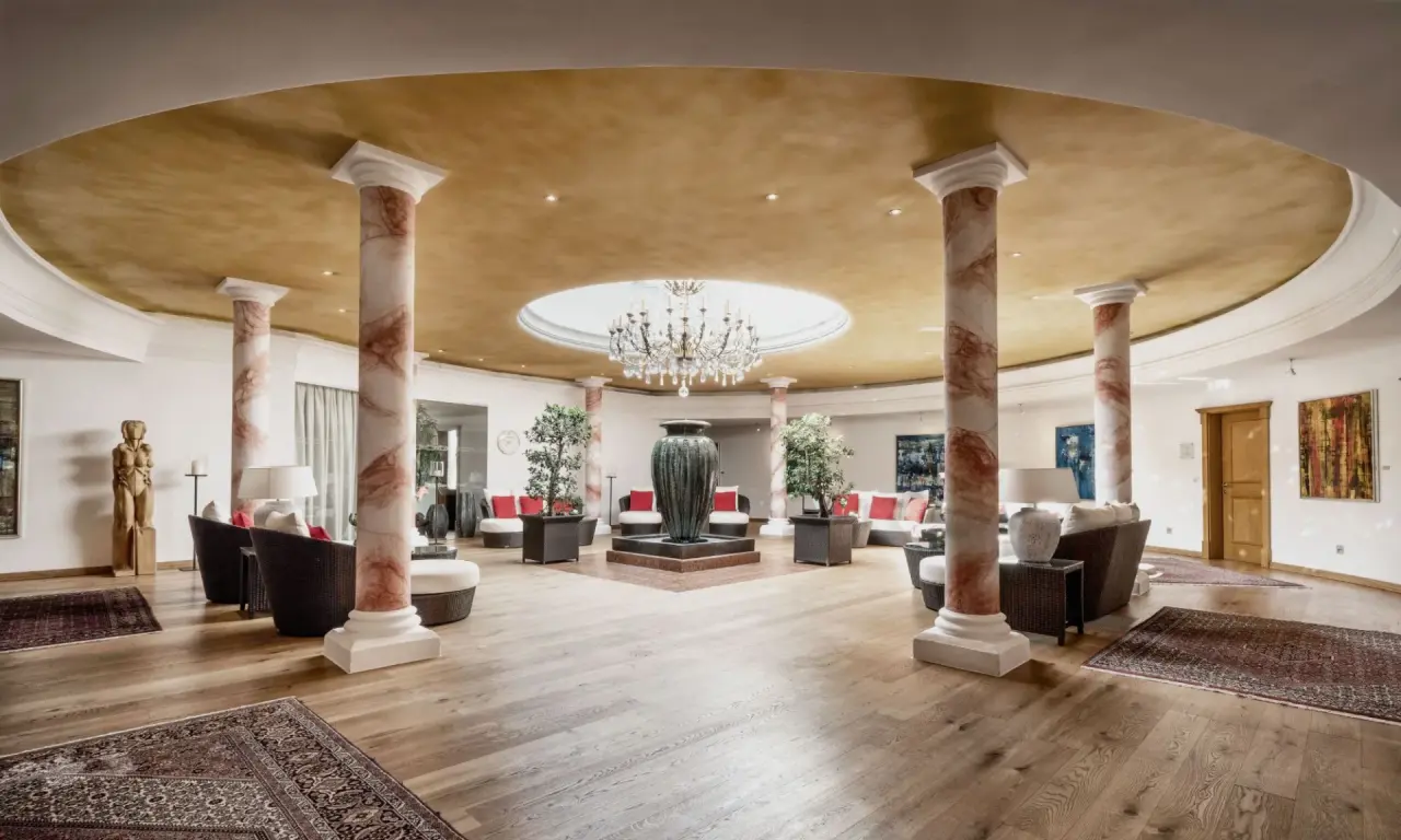 Elegante Lobby des Burg Vital Resort mit Marmorsäulen, Kronleuchter und luxuriösen Sitzbereichen.