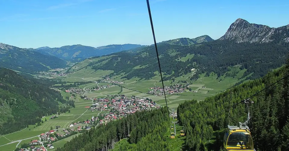 Panoramablick auf das Bergdorf und die Alpenlandschaft mit Seilbahn im Umfeld des Hotel Bergblick.