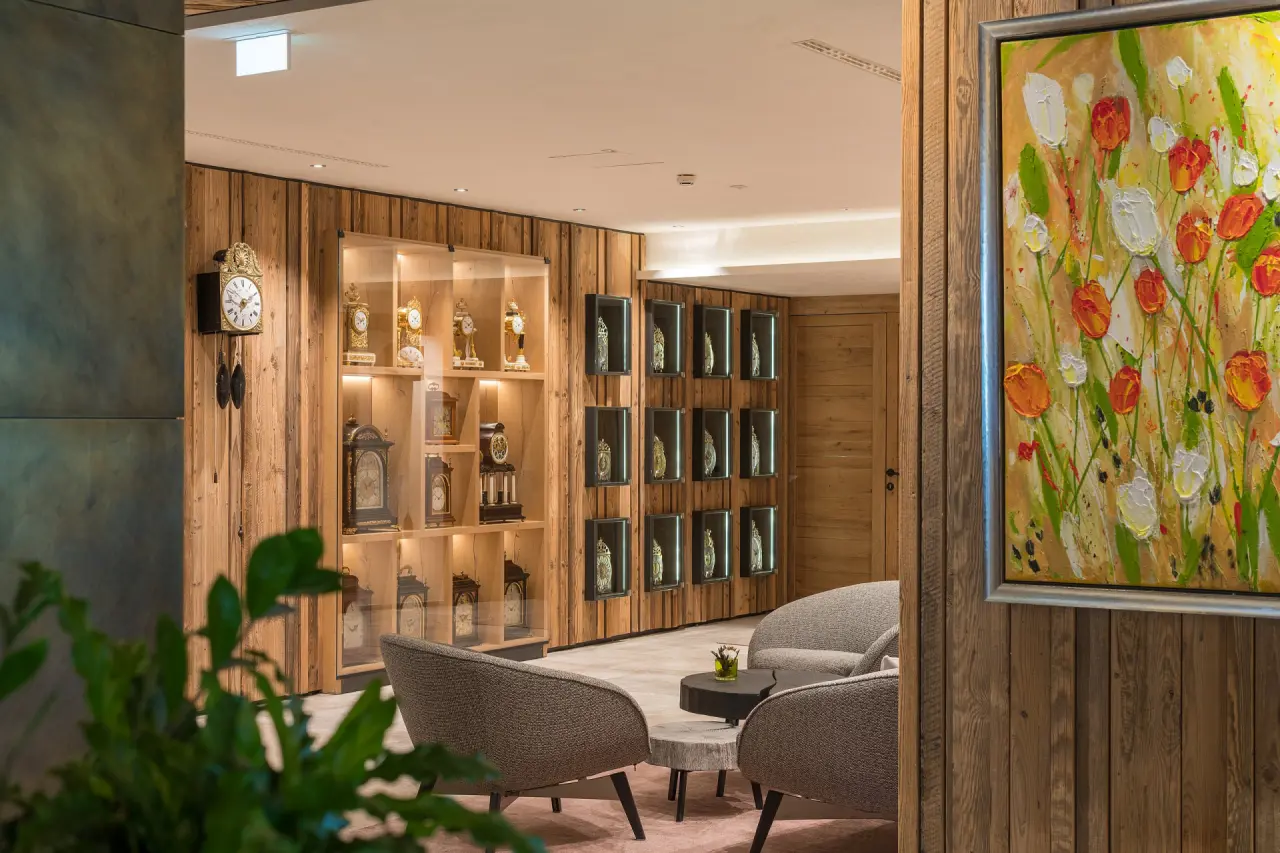 Einladende Hotellobby des Hotel Bergblick mit bequemen Sitzgelegenheiten, Holzwänden und Kunstwerken.