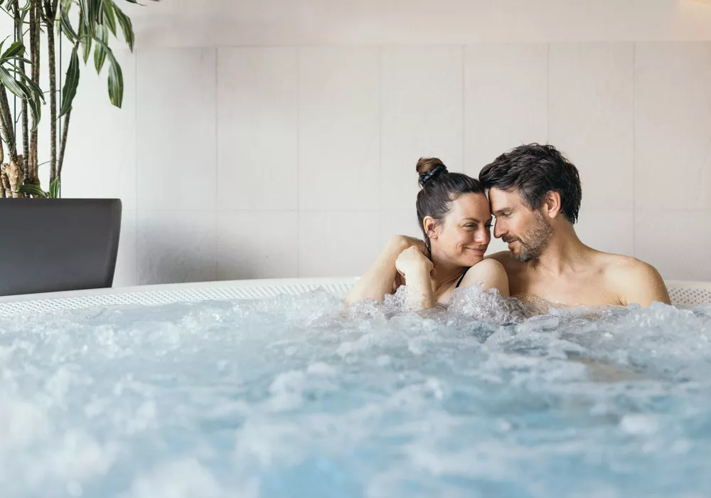 Hotel Kaiserblick in Ellmau – Entspanntes Paar genießt den Whirlpool im Wellnessbereich | Wellnesshotel Tirol