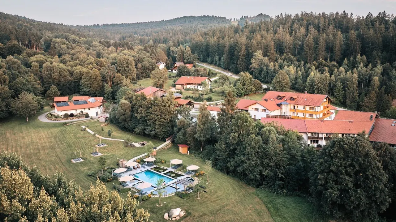 Luftaufnahme des Hotel Waldeck mit Aussenpool und weitläufigem Garten, umgeben von dichtem Wald.