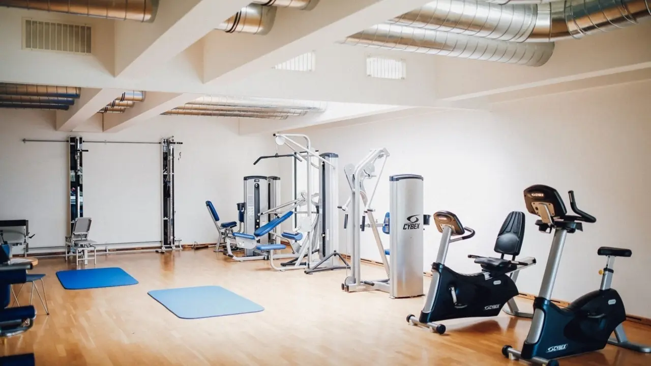 Moderner Fitnessraum mit Kraft- und Cardiogeräten sowie Gymnastikmatten im Ostseehotel Dierhagen.