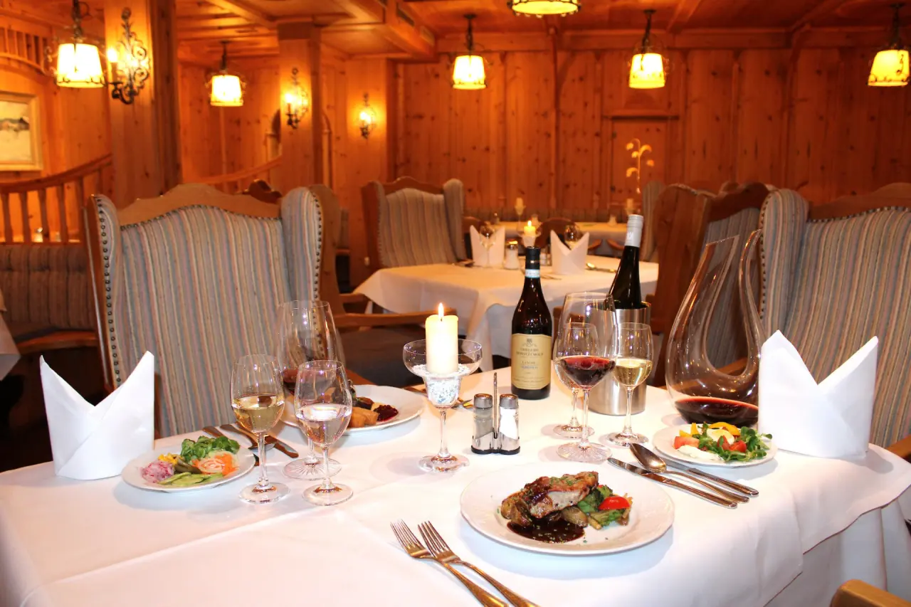 Gemütliches Restaurant im Hotel & Residence Hochriegel mit festlich gedeckten Tischen, Kerzenlicht und regionaler Küche.